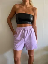 Short lila de cuero sintético con cintura elástica y cordón ajustable.
