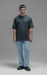 Remera de corte relajado y silueta amplia, con hombros caídos y mangas cortas. Confeccionada en algodón premium, presenta un diseño liso en color gris oscuro.