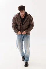 Campera estilo biker de cuero genuino color marrón, con cierre frontal metálico y bolsillos laterales con cierre. Presenta un diseño de corte amplio y estructura robusta.