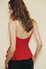 Top negro de escote redondo con tirantes muy finos y bajo acabado en peplum.