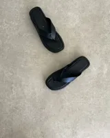 Ojota de plataforma color negro con tira ancha en forma de V de cuero vegano blanco.