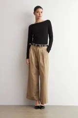 Pantalón pinzado de corte ancho, color beige, con bolsillos laterales y botamanga con vuelta.