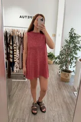 Vestido tejido sin mangas, color rojo con hilo lurex que le da un brillo sutil. Diseño de corte recto y holgado.