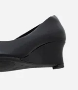 Zapato estilo scarpin con taco anabela de 5 cm, confeccionado en poliuretano con acabado liso y punta fina. Diseño minimalista y cerrado, ideal para uso diario o formal.