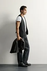 Chaleco regular fit de Zara confeccionado en tejido con lana, color negro, con cuello en V, manga sisa, bolsillos de vivo en la cintura, trabilla ajustable en la espalda y cierre frontal de botonadura.