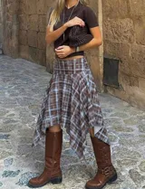 Pollera midi de corte asimétrico con diseño irregular y estampado cuadrillé en tonos marrón y celeste. Presenta cintura alta y silueta fluida con caída liviana.