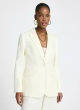 Blazer color blanco roto, de tejido de punto con corte entallado, cuello, dos bolsillos de ribete con solapa, mangas largas con puños abotonados y cierre frontal con botones.