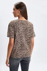 Remera de manga corta con cuello redondo y estampado animal print en tonos tostado y marrón.