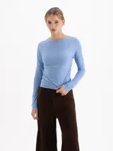 Remera de manga larga en color azul claro, confeccionada en tejido de poliamida y elastano con acabado semitransparente y cuello redondo.