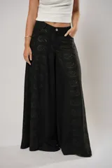 Pantalón negro súper campana de tiro medio en lino con bordados, con bolsillos delanteros y en la espalda. Cierre frontal con cremallera y botón.