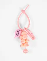 Llavero rosa con colgante de cerditos apilados y campana.