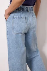 Pantalón de jean celeste de corte holgado, con cintura elástica ajustable con cordón, bolsillos laterales y traseros.