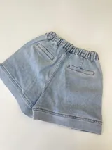 Short de jean celeste con terminaciones desflecadas.