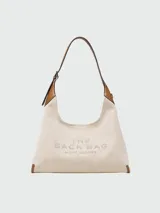 Cartera tipo hobo de Marc Jacobs, confeccionada en lona color beige con detalles en cuero negro. Presenta el logo estampado en el frente y una correa de hombro ajustable.