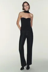 Top palabra de honor negro con brillo, confeccionado en tejido elástico y con aplicación de hilo metalizado.