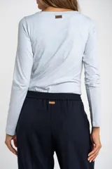 Remera de manga larga ajustada al cuerpo, con cuello redondo, confeccionada en una mezcla de algodón y elastano que aporta suavidad y elasticidad.