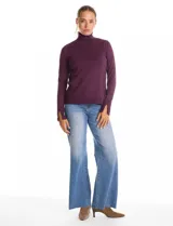 Polera de cuello alto confeccionada en tejido de punto fino, con mangas largas y detalle de tajo en los puños.