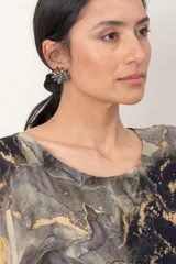 Aros en forma de flor con pedrería brillante en tono gris oscuro.