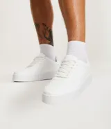 Championes urbanos de caña baja marca Viko, confeccionados en material sintético (PU) color blanco. Presentan diseño con recortes laterales, perforaciones decorativas, puntera redondeada y cierre mediante cordones al tono.