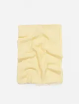 Pashmina lisa color amarillo pastel, rectangular, con terminaciones desflecadas.