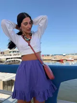 Bandolera pequeña tipo porta celular, color verde claro, confeccionada en cuero sintético. Cuenta con cierre principal, bolsillo frontal con tapa y broche a presión, y correa ajustable extraíble.