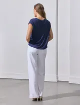 Blusa color beige de modal con escote en V, abertura central con botones y ruedo anudado. Marca French Laundry.