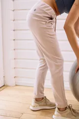 Pantalón babucha deportivo color lila, con elástico en la cintura y puños, cordones regulables y dos bolsillos laterales.