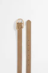 Cinturón de textura gamuzada en color beige, con hebilla metálica ovalada en tono dorado.