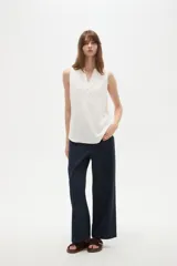 Musculosa de poliéster color blanco, con cuello en V y diseño holgado sin mangas.