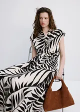 Vestido midi de viscosa con estampado de hojas en blanco y negro, sin mangas, con cuello camisero, cierre frontal de botones y cinturón a juego.