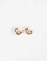 Aros tipo argolla gruesa de diseño compacto y acabado brillante en tono dorado.