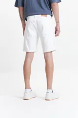 Bermuda de jean de corte regular, color blanco, con dobladillo en el ruedo, cierre frontal con botón y bolsillos laterales y traseros.