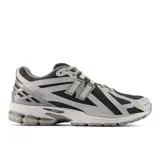 Championes New Balance modelo 1906R, de estilo running retro, color negro y gris con detalles plateados.