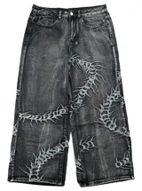 Jean baggy fit de tiro bajo en denim color negro con efecto lavado. Presenta bordados detallados en toda la prenda con motivos orgánicos y abstractos.