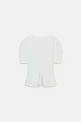 Camiseta negra de cuello redondo con escote en pico, manga corta abullonada y bajo con diseño peplum.