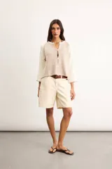 Saco de algodón tejido, color beige con mangas y detalles en blanco, escote en V y cierre frontal de botones.