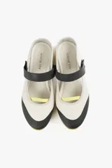 Zapato de diseño urbano color blanco con detalles en negro y amarillo, suela dentada y tira de velcro en el empeine.