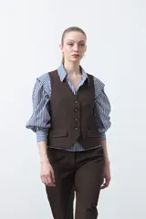 Chaleco sastrero color marrón oscuro, con escote en V, cierre frontal de botones y pinzas de entalle.