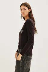 Remera de manga larga color negro, confeccionada en algodón, con estampa frontal bordada en hilo metalizado con la frase 'PARIS JE T'AIME'.