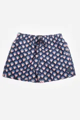 Short de baño celeste con estampado de hojas pequeñas en tonos verdes y blancos. Cuenta con cintura elástica con cordón ajustable, bolsillos laterales y un parche circular con logo en la parte inferior.