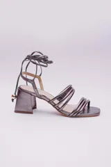 Sandalias doradas con taco cuadrado y tiras finas que se atan al tobillo. Capellada, forro y plantilla 100% de cuero.