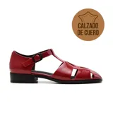 Sandalias de cuero negro con diseño de tiras cruzadas y hebilla lateral. Taco bajo.