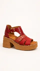 Sandalias de cuero color suela, con plataforma alta y taco ancho. Presentan tiras cruzadas en el empeine con mix de texturas y cierre de hebilla metálica en el tobillo.