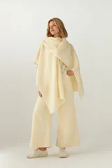 Ruana de lana fina sin teñir, con textura acanalada y terminaciones artesanales en crochet. Diseño versátil y envolvente, ideal para usar como abrigo ligero durante todo el año.