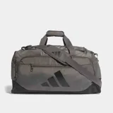 Bolso deportivo Adidas Training Defender, confeccionado en material ripstop resistente. Cuenta con un compartimento principal amplio con cierre de dos direcciones, correa para el hombro extraíble y acolchada, y perforaciones de ventilación cortadas a láser. Diseño en color gris con logo de la marca en negro.