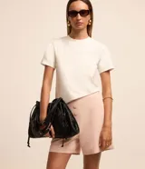 Short de sastrería color rosado, de tiro alto con detalles de pinzas frontales y cartera abotonada con cuatro botones revestidos. Presenta diseño recto y estructurado.