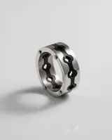 Anillo de acero italiano con diseño de banda ancha y calados en forma de trébol con fondo negro.
