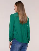 Camisa de estilo boho, color verde, con cuello camisero, escote en V y botonadura frontal con botones perlados. Cuenta con una pechera con bordados geométricos y florales a contraste, mangas largas abullonadas con puños abotonados y delicados bordados dispersos.
