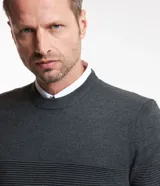 Suéter de punto para hombre con cuello redondo y manga larga. Presenta un diseño combinado con una parte superior lisa y una parte inferior con canalé texturizado horizontal. Marca Marfinno.