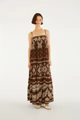 Vestido largo marrón con estampado estilo paisley y mariposas en tonos crudos, de corte fluido, con tirantes finos y diseño escalonado en la falda.